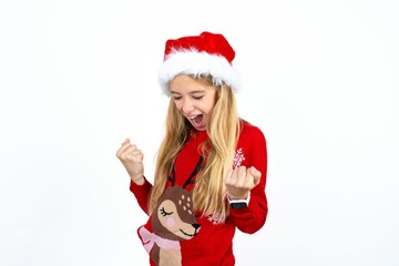 Beautiful girl wearing red knitted sweater very happy and excited doing winner gesture with arms raised, smiling and screaming for success. Celebration concept.