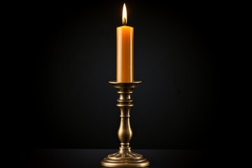 Antique brass candlestick holder with a lit taper candle