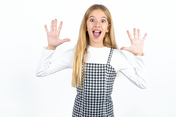Delighted positive Beautifu blonde kid girl opens mouth  and arms palms up after having great result