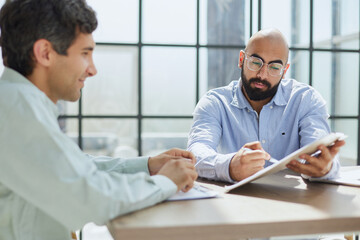 Obraz premium Startup partners discussing project at laptop, watching video presentation