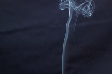 White smoke curls beautifully in the air on a blue background	
