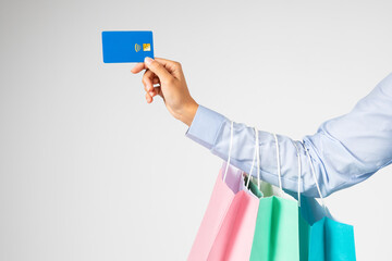 Hand of young european woman holding many shopping bags, credit card, enjoying shopping