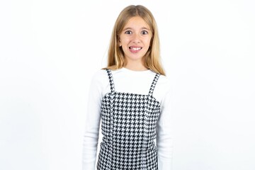 Beautiful girl wearing plaid printed dress over white studio background having stunned look. 