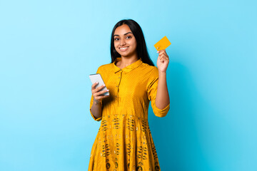Hindu lady using card and smartphone for online shopping, studio