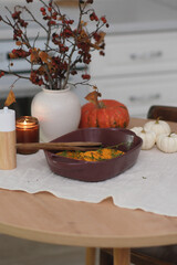 Cooking of baking pumpkin and thyme in ceramic dish on wooden table background. Top view.
