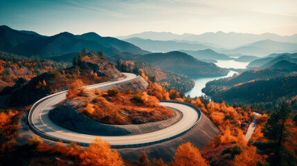 Aerial view over winding road on a mountain top with colored autumn trees