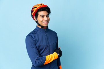 Venezuelan cyclist man isolated on blue background pointing back - obrazy, fototapety, plakaty