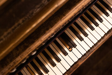 Piano keyboard background. Brown wood style. White and black keys. Instrument play background. Warm color closeup piano. Classical music background. Empty copy space old vintage retro piano instrument