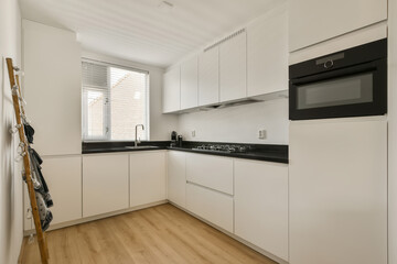 a kitchen with white cupboards and black counter tops on the counters in this photo is taken from the inside
