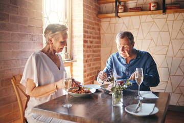 Food, date and senior couple eating at fine dining restaurant and having lunch together at a table. Elderly man and woman with dinner in marriage at cafe or coffee shop during retirement for love