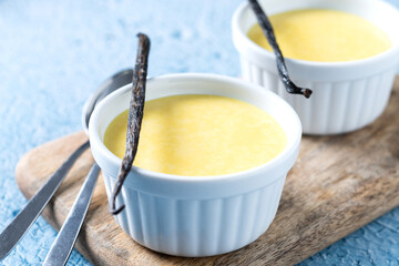Homemade vanilla custard on blue background.
