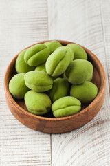 Ripe juicy green apricots on a white wooden background. Fruit harvesting