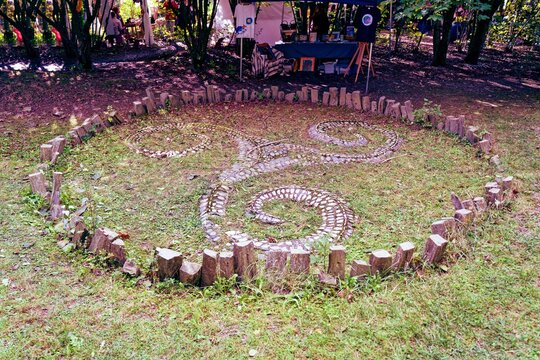 Wooden Celtic triskelion sign standing in a green grassy meadow in Switzerland