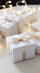 Gift boxes on white table with garland lights, closeup.