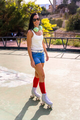 Middle aged skater woman roller skating in park smiling at camera
