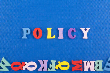 POLICY word on blue background composed from colorful abc alphabet block wooden letters, copy space...