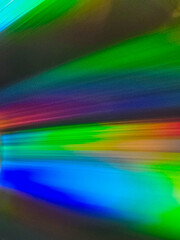 Close-up to interesting abstract patterns created by the rays of sunlight reflecting from the surface of the CD lying on the desk, Lodz, Poland.