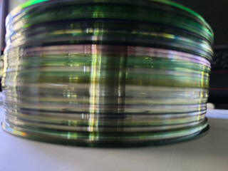 Close-up to interesting abstract patterns created by the rays of sunlight penetrating through a pile of CD arranged on the desk, Lodz, Poland.