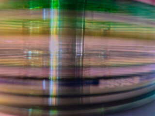 Close-up to interesting abstract patterns created by the rays of sunlight penetrating through a pile of CD arranged on the desk, Lodz, Poland.