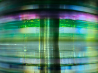 Close-up to interesting abstract patterns created by the rays of sunlight penetrating through a pile of CD arranged on the desk, Lodz, Poland.