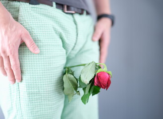 Withered flower between the man legs. Weak erection during sex in man concept - obrazy, fototapety, plakaty