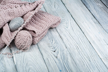 Knitting wool and knitting needles. Ball of wool with spokes for handmade knitting on wooden table.
