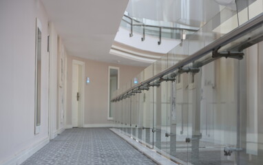 Obraz premium Empty corridor with doors to rooms in hotel building. Modern architecture public building concept
