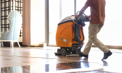 Cleaner washing floor in hotel using special machine closeup. Professional office cleaning concept