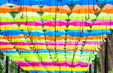 Colorful umbrellas hung in the sunny sky. Street decoration, Eco-shading ideas