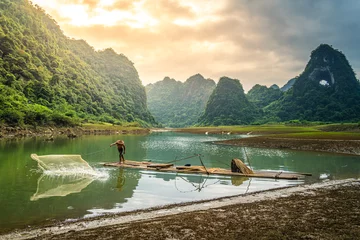 Foto op Plexiglas view of fishermen fishing on river in Thung mountain in Tra Linh, Cao Bang province, Vietnam with lake, cloudy, nature © CravenA
