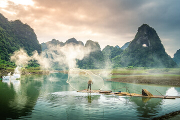 view of fishermen fishing on river in Thung mountain in Tra Linh, Cao Bang province, Vietnam with lake, cloudy, nature - obrazy, fototapety, plakaty