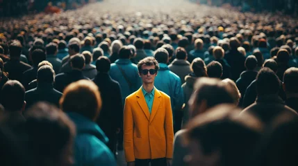Fotobehang Man in yellow jacket standing out from large crowd of people in the middle of the street © IBEX.Media
