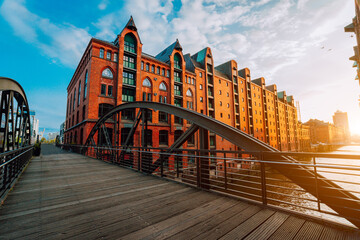 Arch bridge over canals in the Speicherstadt of Hamburg. Warm evening sun light on red brick...