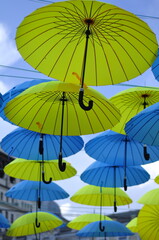 Colorful blue and yellow umbrellas hanging over the old streets of the city center
