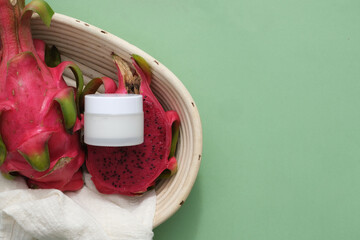 Fresh dragon fruit and an unlabeled white cosmetic jar are placed in a basket on the left side of the frame. Space on the right for text design and related images