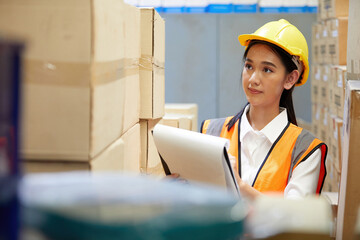 female factory worker finding and looking cardboard in the warehouse storage