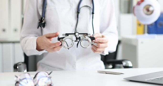 Ophthalmologist optometrist holds glasses for selection of lenses. Myopia farsightedness astigmatism and wearing glasses optics concept