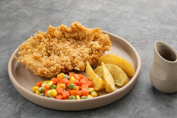 Crispy Chicken Steak with french fries and vegetables. 
