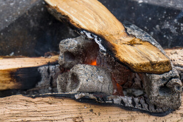 Smoldering firewood for lighting a fire in a barbecue. Firewood that has already begun to turn into...