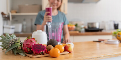 Beauty healthy asian woman making fruit smoothie with blender. woman drinking glass of fruit smoothie in kitchen. Diet concept. healthy drink - obrazy, fototapety, plakaty