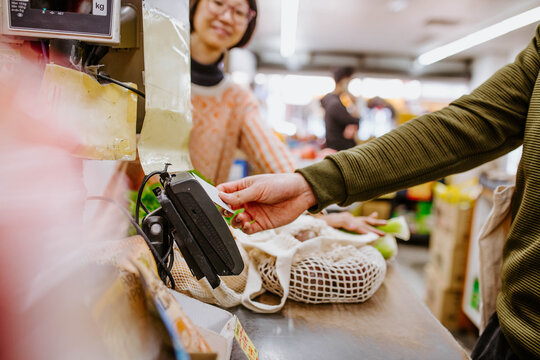 Arm of man paying by card at supermarket counter