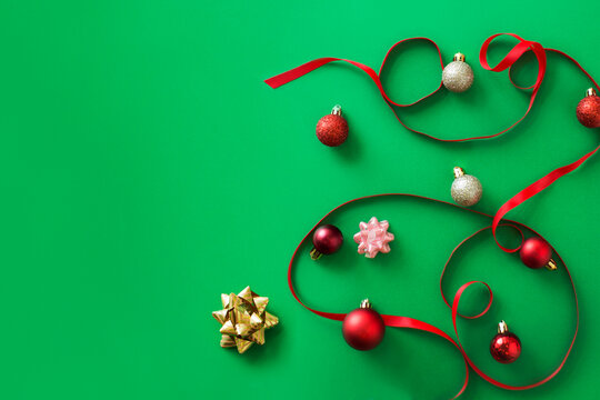 Christmas theme red ribbon and ornaments on green border background.