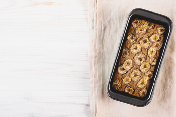 Delicious freshly baked homemade banana bread cake with no gluten and sugar free, top view on white wodden background, flat lay style. Healthy sweet food. Negative space for text.