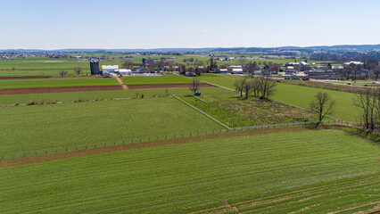 An Aerial View of Pennsylvania Dutch Farmlands with an Amish Cemetery in it on a Sunny Spring Day