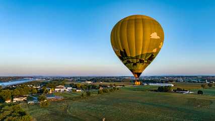 An Aerial View of a Golden Hot Air Balloon, Floating Across Fields of Corn, in rural America, on a Sunny Summer Morning