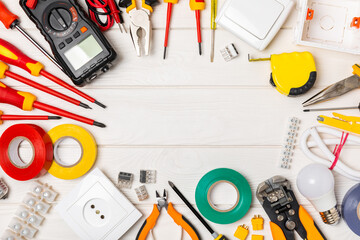 Electrician tools on background. Multimeter,construction tape,electrical tape, screwdrivers,pliers,an automatic insulation stripper, socket and LED lamp. Flatley. electrician concept.