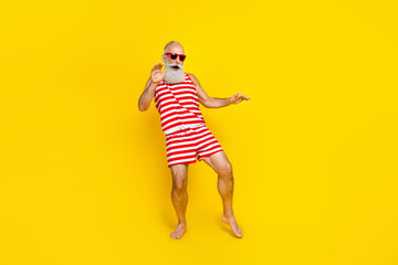 Full length photo of cool funky elderly guy dressed striped red swimsuit dancing having fun isolated yellow color background