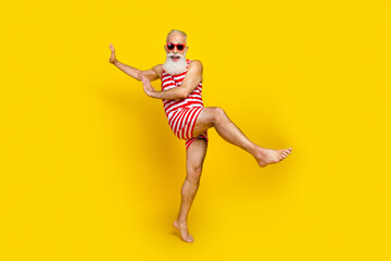 Full length photo of excited funky elderly guy dressed striped red swimsuit having fun beach disco...