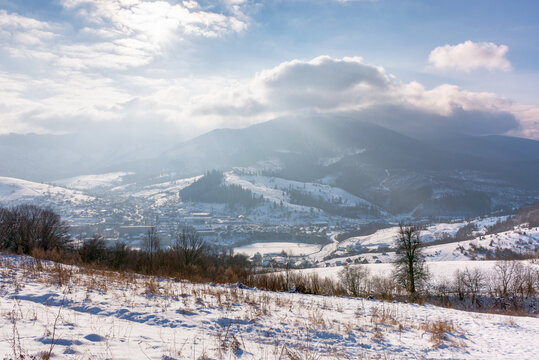 mountainous carpathian countryside in winter. rolling landscape with snow covered hills. misty weather with clouds above the ridge