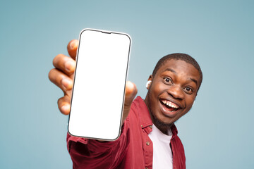 Mobile advertisement. Overjoyed black man pointing at cellphone with empty white screen on blue...